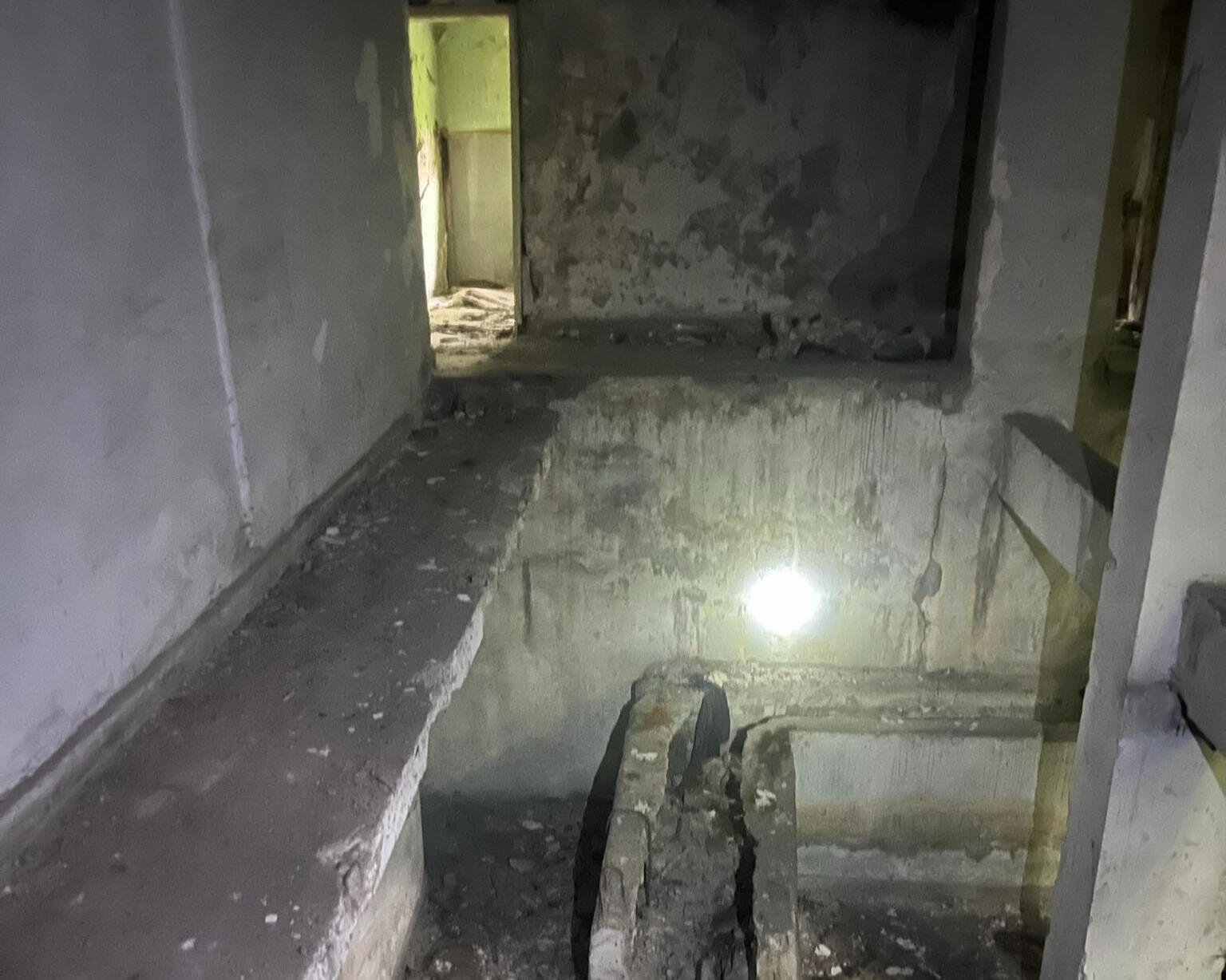 Lower-level basement space showing concrete floor slab and foundational structure