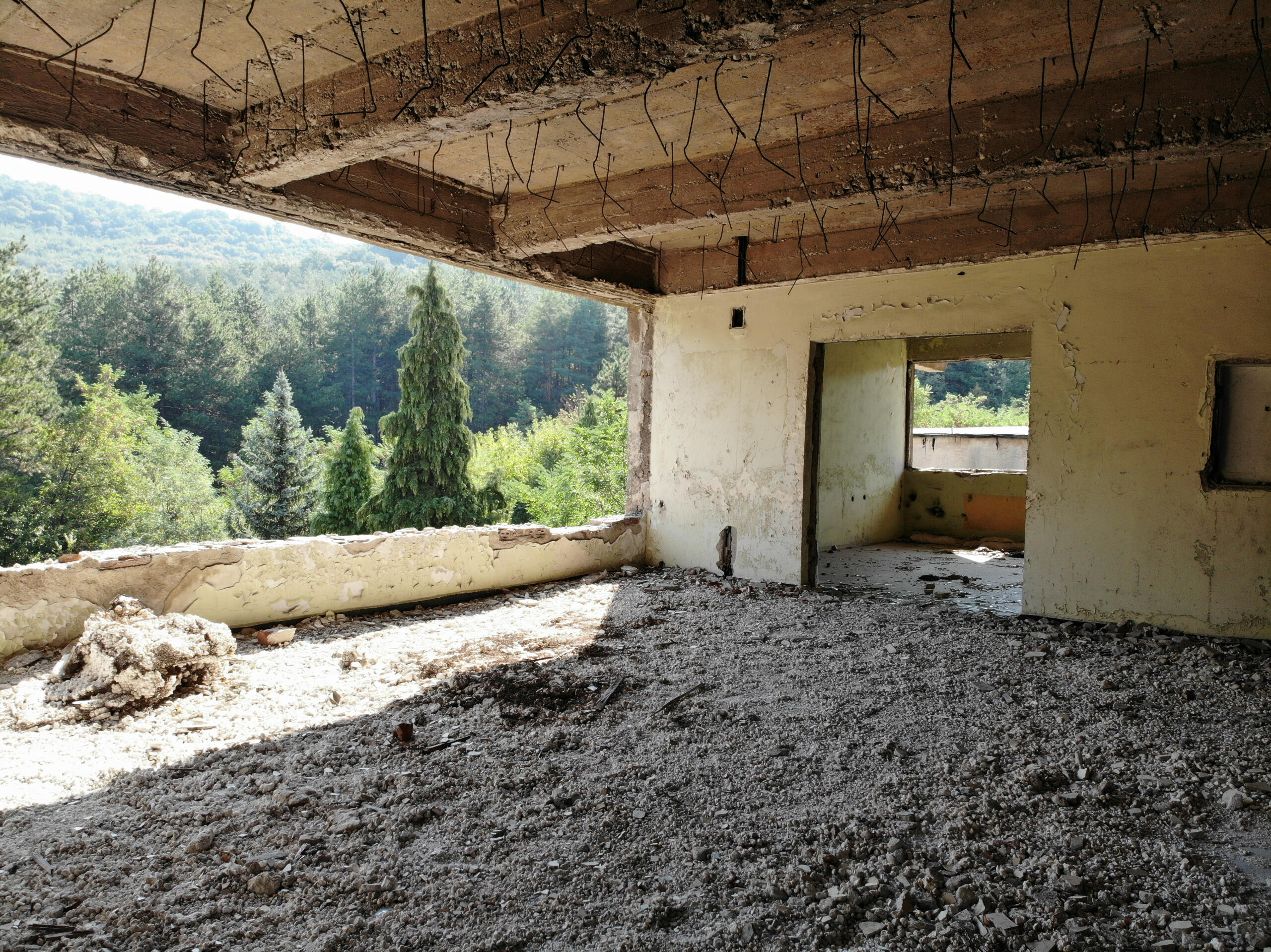 Upper-level room with deteriorated ceiling and expansive mountain forest views